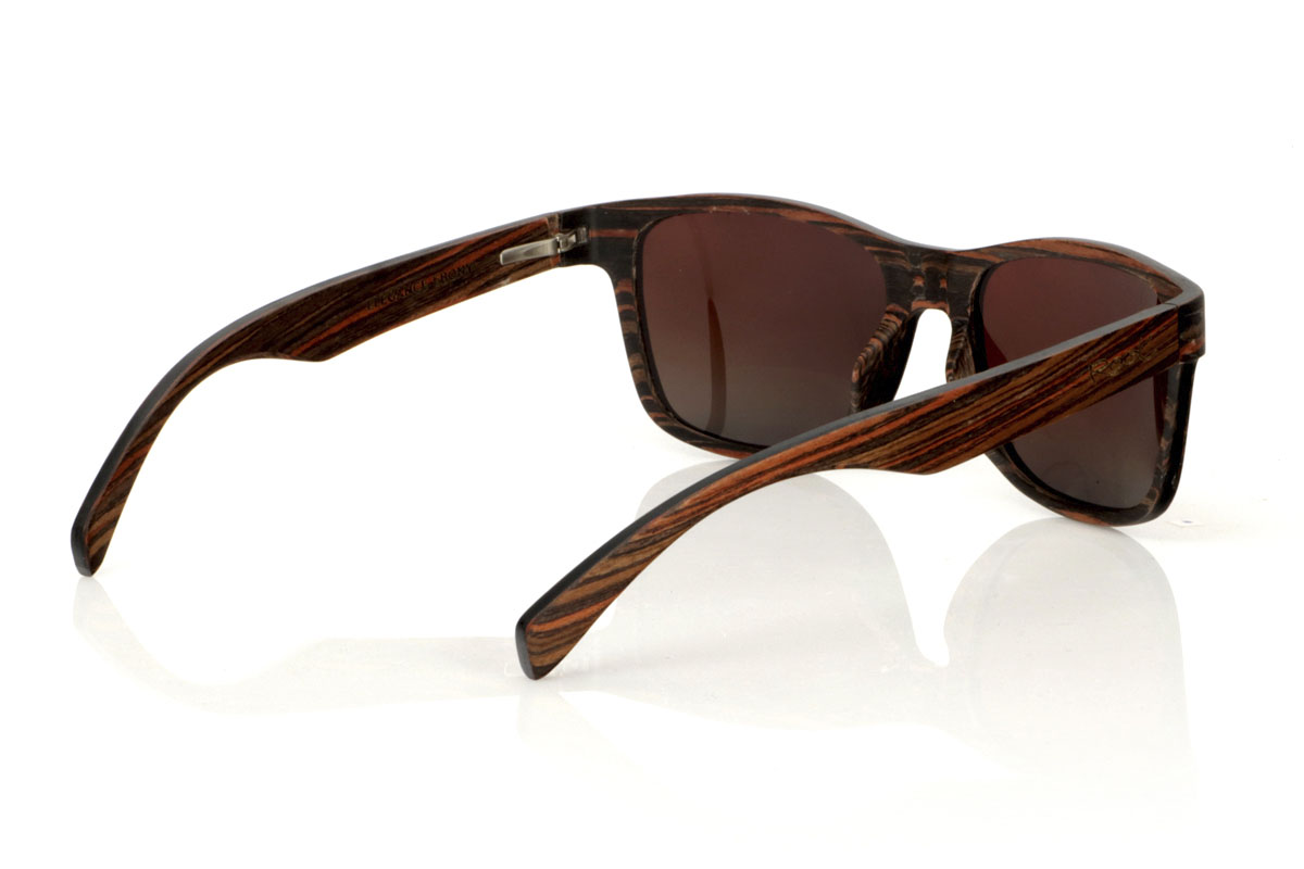 Wood eyewear of Ebony ELEGANCE. ELEGANCE wooden sunglasses stand out for their less angular frame, designed to fit wider faces or for those who prefer oversized glasses. This model is characterized by its unique construction, with laminated ebony wood on the exterior and interior and sheets of maple wood interspersed on the contravein, and by the detail of the curvature of the frame in the grip to the temples, offering not only an effect Impressive visual but also a robust structure. With generous measurements of 155x50mm and a caliber of 55, these glasses are the perfect choice for those looking to combine comfort with a bold and elegant style. for Wholesale & Retail | Root Sunglasses® 